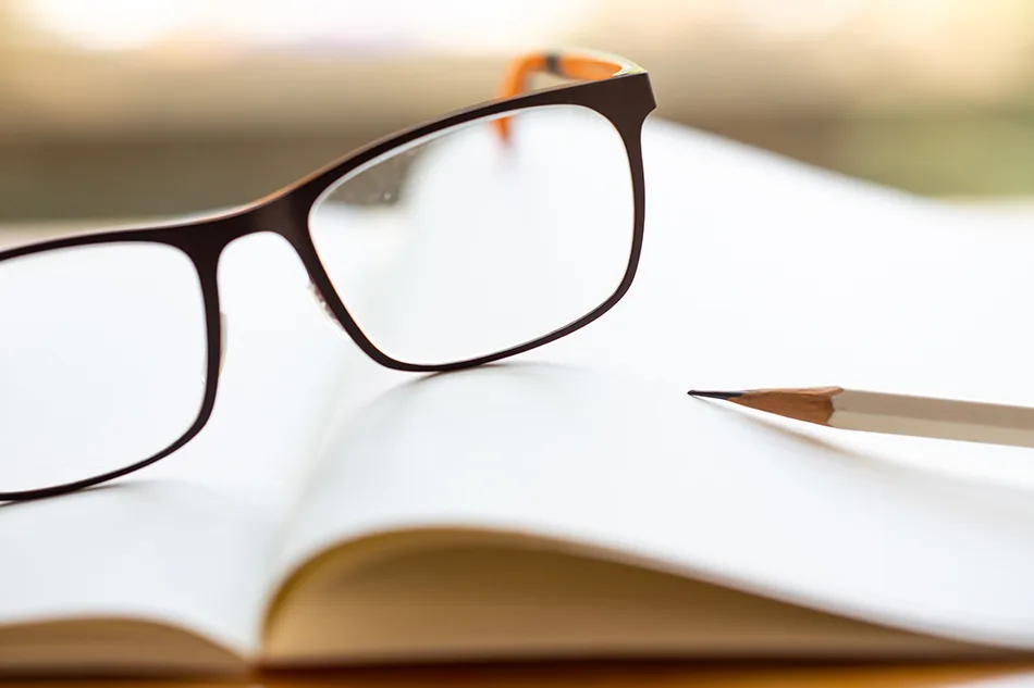 Brille liegt auf einem aufgeschlagenen Notizbuch